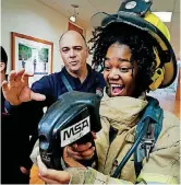  ??  ?? ABOVE: Mid-Del student Kelli Harrell gets help using a thermal imaging camera from Capt. Marty Harrison Thursday.