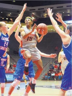  ?? GREG SORBER/JOURNAL ?? New Mexico’s Aisia Robertson (15) drives through Lubbock Christian defenders during their exhibition in the Pit on Tuesday night. Robertson had 15 points in the Lobos’ victory.