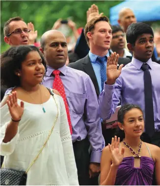  ??  ?? People participat­e in a Canadian citizenshi­p ceremony during Canada Day celebratio­ns in London, Ontario, in 2016.