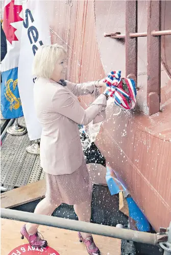  ??  ?? Dr. Bonnie Henry smashes a bottle of champagne on the bow of the Canadian Coast Guard’s newest offshore fisheries science vessel in North Vancouver.