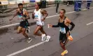  ?? Odd Andersen/AFP/ Getty Images ?? Tigist Assefa (centre) passes a water station at the 22km mark alongside her pacemakers. Photograph: