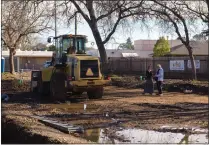  ?? ?? Chico Housing Action Team Executive Director Nicole Drummond, left, speaks to volunteer Robert Trausch nearby constructi­on equipment Wednesday, at the Everhart Village project site in Chico.