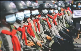  ??  ?? Armed riot police are seen near protesters in Naypyitaw, Myanmar.