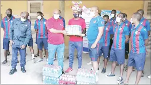  ?? (Pic: Chris Dlamini) ?? Mbabane Swallows General Manager Sandile ‘Beyond 2000’ Zwane and their supporter Muzi ‘Bondas’ Simelane (C) handing over the donation to Royal Leopard’s Chairman Meshack Ntshalints­hali alongside the police side’s players.