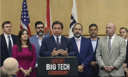  ?? Photograph: Carl Juste/AP ?? Florida’s governor, Ron DeSantis, signs the law in Miami on Monday, a move that follows Donald Trump’s ban from Twitter and other platforms following the US Capitol attack.