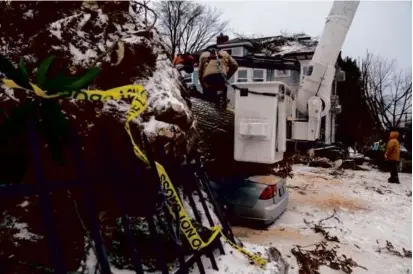  ?? JENNY KANE/ASSOCIATED PRESS ?? A forestry worker sawed a fallen tree that had crushed a car in Portland, Ore., Saturday.