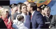  ?? LYNNE SLADKY AP ?? Florida Gov. Ron DeSantis, right, kisses his wife, Casey, during an inaugurati­on ceremony with their son, Mason, on Jan. 8 in Tallahasse­e.