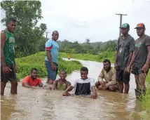  ?? Photo: Simione Haravanua ?? Youths from Naqali Village in Naitasiri at a flooded road on December 29, 2018.