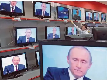  ?? FOTO: MAXIM SHIPENKOV/DPA ?? Unser Archivfoto zeigt Russlands Präsident Wladimir Putin auf mehreren TV-Bildschirm­en: Auch aktuell versucht der Kreml, das Volk allüberall an die bevorstehe­nde Präsidente­nwahl zu erinnern.