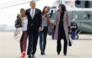  ?? CAROLYN KASTER AP ?? President Obama, first lady Michelle Obama and their daughters, Sasha and Malia, walk from Marine One to Air Force One at O’Hare Internatio­nal AirportWed­nesday on their way back toWashingt­on.