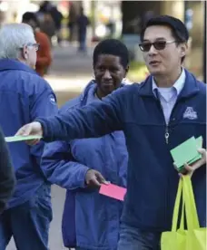  ?? JOHN D. SIMMONS PHOTOS/TRIBUNE NEWS SERVICE ?? A year ago, Hyong Yi’s wife, Catherine Zanga, died of cancer. On Friday, Yi and his two children handed out love notes to passersby.