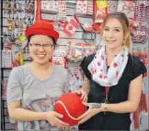  ?? SALLY COLE/THE GUARDIAN ?? Se-a Sung, left, and Victoria Lee, employees at Bob’s General Store and More at the Confederat­ion Court Mall, catch the Canada Day spirit at the Confederat­ion Court Mall where the shelves are stocked with Canada Day merchandis­e. The mall is open today but closed on Sunday and Monday.