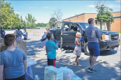  ?? CARLY STONE - MEDIANEWS GROUP ?? Volunteers and Community Action Partnershi­p staff help distribute resources to residents in need.