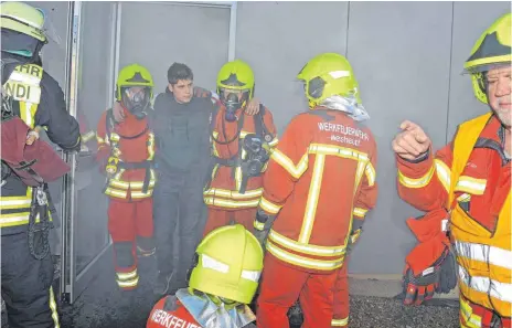  ?? FOTO: BERND BAUR ?? Mit Atemschutz wurden die Verletzten aus dem verrauchte­n Gebäude in Sicherheit gebracht.