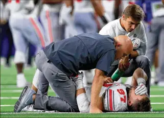  ?? TOM PENNINGTON / GETTY IMAGES ?? The Buckeyes’ Nick Bosa is down after being injured in the third quarter against TCU in Arlington, Texas, Saturday night. Bosa walked to the locker room under his own power, but he limped back onto the sideline in street clothes later in the third quarter.