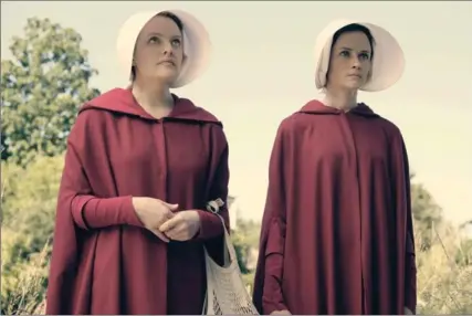  ?? GEORGE KRAYCHYK, HULU ?? Elisabeth Moss, left, as Offred and Alexis Bledel as Ofglen in the Hulu series “The Handmaid’s Tale,” based on the novel by Margaret Atwood.