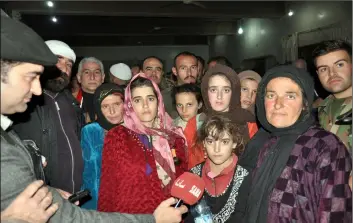  ?? SANA VIA AP ?? In this photo released by the Syrian official news agency SANA, women and children who were rescued from the Islamic State group in the Hamima area east of the historic town of Palmyra, after they arrived to the southern province of Sweida, Syria, on Friday.