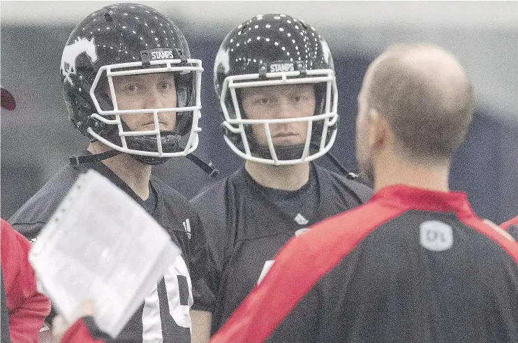  ?? — CP FILES ?? Calgary Stampeders quarterbac­ks Bo Levi Mitchell, left, and Andrew Buckley listen to head coach Dave Dickenson at practice for the 104th Grey Cup.