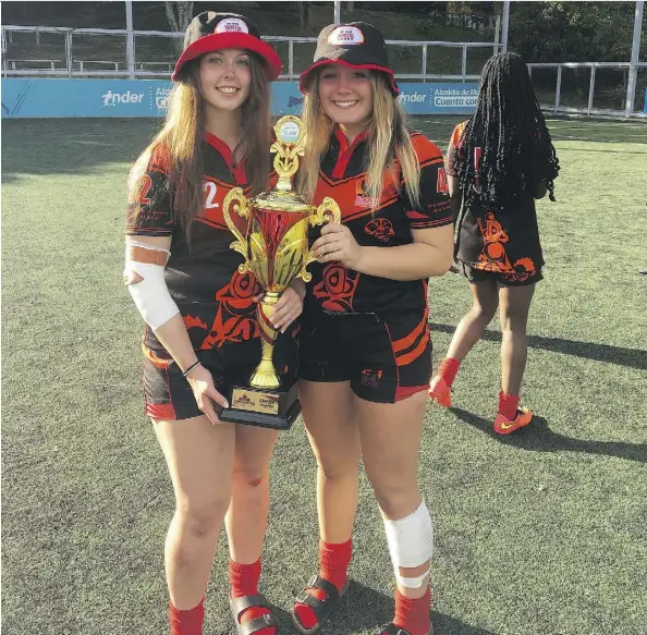  ??  ?? Avery Jeffery, left, and Kiana Kruger, both 16-year-old St. Albert high school students, returned from Colombia last week with a gold cup after winning a rugby sevens tournament for their age group. The girls represente­d the Dog River Howlers, a...