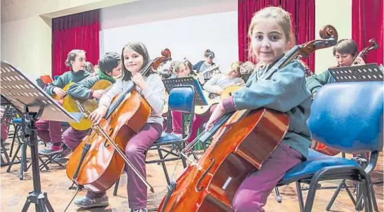  ?? (GENTILEZA EXTENSIÓN UNC) ?? Afinados. Chicas y chicos aprenden a tocar instrument­os junto con profesores de la Universida­d Nacional de Córdoba.