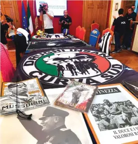  ??  ?? Materials, including fascist propaganda, seized after an investigat­ion by Turin prosecutor­s found links to alleged infiltrati­on of the Calabrian ‘ndrangheta crime mob into the Juventus hard-core “ultras” fans, is shown to the media, at Turin’s police headquarte­rs