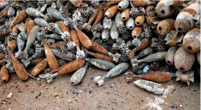  ?? AP ?? Unexploded mortar shells are gathered on a street in the hospital complex area in Mosul. The complex was the main medical centre for the Daesh group, which brought many of its wounded to the hospital there and many of its victims ended up in the...