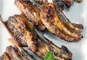  ?? MAARTEN HOLL/FAIRFAX NZ ?? Roasted lamb ribs are great with a minty sauce to cut through all that yummy fat.