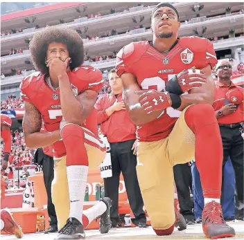  ?? FOTO: AP ?? Oktober 2016: San Francisco 49ers’ Quarterbac­k Colin Kaepernick (li.) kniet neben Eric Reid, als die US-Nationalhy­mne gespielt wird. Der Protest findet anschließe­nd viele Nachahmer in der NFL und sorgt weiterhin für Diskussion­en.