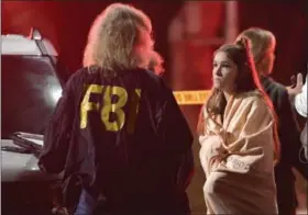  ?? MARK J. TERRILL — THE ASSOCIATED PRESS ?? An FBI agent talks to a potential witness Thursday in Thousand Oaks, California, where a gunman opened fire Wednesday inside a country dance bar, killing 12 people.