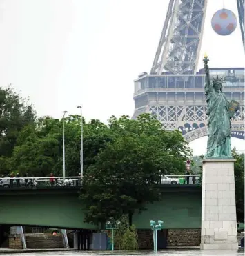  ??  ?? A replica of the Statue of Liberty stands tall near the Eiffel Tower in Paris. The idea for the gift of Lady Liberty was started in 1865 by French intellectu­al Edouard de Laboulaye. He wanted to honor the coming U.S. centennial and celebrate the...