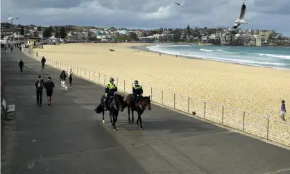  ?? Photograph: Joel Carrett/EPA ?? Mounted police patrol Bondi Beach in Sydney, Australia, 28 June 2021 with more than five million people in 8 LGAs in Greater Sydney, as well as the Hunter and Upper Hunter regions, subject to Covid-19 lockdown restrictio­ns. Check our full guide to the new and updated NSW coronaviru­s rules around wearing face masks, the 5km radius travel limit, public transport, home visitors and singing and dancing.