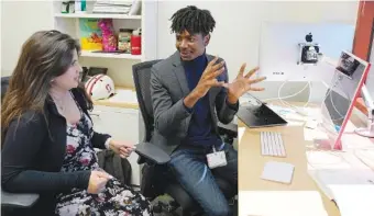  ?? AP PHOTO/ERIC RISBERG ?? Post-doctoral researcher Tofunmi Omiye, right, gestures Tuesday while talking in his office with assistant professor Roxana Daneshjou at the Stanford School of Medicine in Stanford, Calif.