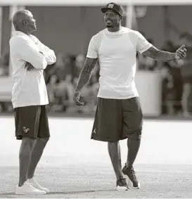  ??  ?? Is there a comeback in the making as retired wide receiver Andre Johnson, right, talks to Texans general manager Rick Smith at Monday’s practice? Johnson was admittedly impressed with the current quarterbac­k situation for his old team.