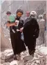  ?? AFP / Getty Images ?? A family trudges through the rubble in Aleppo, Syria.