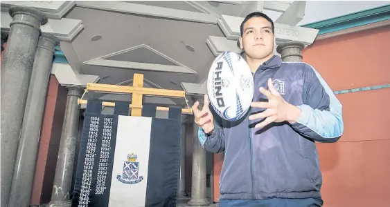  ?? Photo / Paul Taylor ?? Napier Boys’ High School 1st XV rugby captain Tyrone Thompson and the Polson Banner, which will be up for grabs during today’s annual clash against Palmerston North Boys’ High School in Napier.