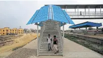  ??  ?? People walk down the steps from a pedestrian overpass at the new railway station in Jainagar, India, the end of the line from Nepal.