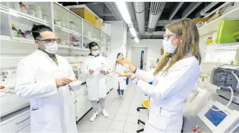  ?? FOTO: IRIS MARIA MAURER ?? Laborprakt­ika sind Teil des Pharmazie-Studiums an der Uni des Saarlandes: Agnes-Valencia Weiß (r.), wissenscha­ftliche Mitarbeite­rin für Biopharmaz­ie und Pharmazeut­ische Technologi­e, zeigt Studenten ein Präparat.