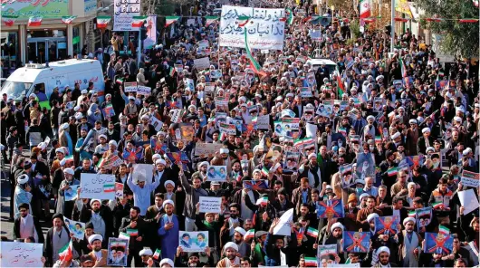  ??  ?? Counter-protest: Government supporters march yesterday in the holy city of Qom, 80 miles south of Iran’s capital Tehran