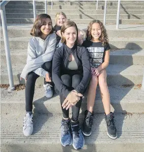  ?? ARLEN REDEKOP ?? Coquitlam mom Tiffany Glasco sits with daughters Olivia, left, and Kiera, right, and friend Ana, top, in front of Alderson Elementary School. Glasco agrees with a poll that says after-school programs make kids more sociable and better learners.