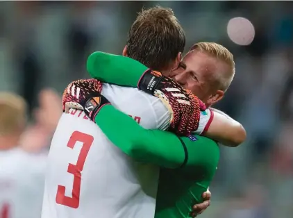  ??  ?? Denmark's goalkeeper Kasper Schmeichel, right, hugs Jannik Vestergaar­d