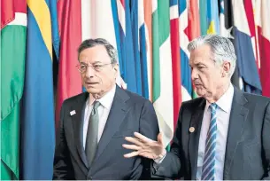  ?? ANDREW HARRER/BLOOMBERG ?? ECB president Mario Draghi, left, walks with U.S. Fed chair Jerome Powell. The divergence between the world’s top two central banks reflect a division in economic fortunes.