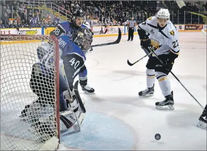  ?? JEREMY FRASER/CAPE BRETON POST ?? Vasily Glotov, right, of the Cape Breton Screaming Eagles, swats at the puck as goaltender Callum Booth of the Saint John Sea Dogs watches. Cape Breton won the game 3-2 in overtime.