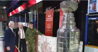  ??  ?? Hockey Hall of Fame Chairman Lanny McDonald, left, Calgary Flames President of Hockey Operations Brian Burke and Brigadier General Kevin Cotten helped unveil the boards at the Hockey Hall of Fame on Tuesday.