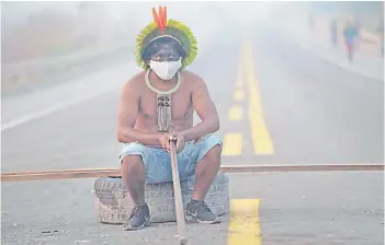  ?? AFP file photo ?? A member of the Kayapo tribe sits after they blocked highway BR163 during a protest on the outskirts of Novo Progresso in Para State, Brazil. Political momentum has grown as evidence of climate change mounts.—