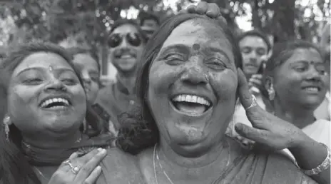  ?? RAJESH KUMAR SINGH/AP ?? Samajwadi party supporters smear their faces with powder as they celebrate their lead in Uttar Pradesh state Tuesday. The regional party triumphed.