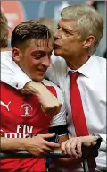  ??  ?? SEALED WITH A KISS: Wenger shows his appreciati­on to Ozil (left)