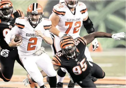  ?? Gary Landers / Associated Press ?? Browns quarterbac­k Johnny Manziel (2) breaks away from the Bengals’ Wallace Gilberry on a scramble during the first half Thursday. Manziel ran four times for 31 yards and finished 15-of-33 for 168 yards and one TD through the air in a 31-10 loss.