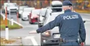  ?? AFP ?? A police officer stops cars to check the drivers’ vaccinatio­n status at the Südring in Klagenfurt, Austria, on Monday.