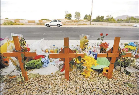  ?? Elizabeth Brumley Las Vegas Review-Journal @EliPagePho­to ?? A car passes a memorial site on Wednesday where three juveniles between the ages of 12 and 15 were hit by a car on Desert Inn Road east of Nellis Boulevard on Sept. 30.