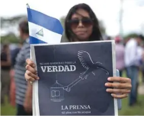  ??  ?? VERDAD. Una reportera del diario La Prensa muestra una edición del periódico en un plantón por la libertad en Managua. (DW)